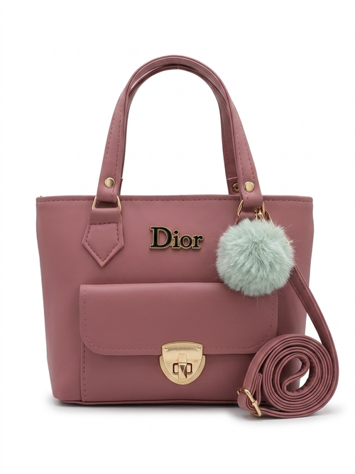 Pink handbag with gold accents and a fluffy pom-pom on a white background